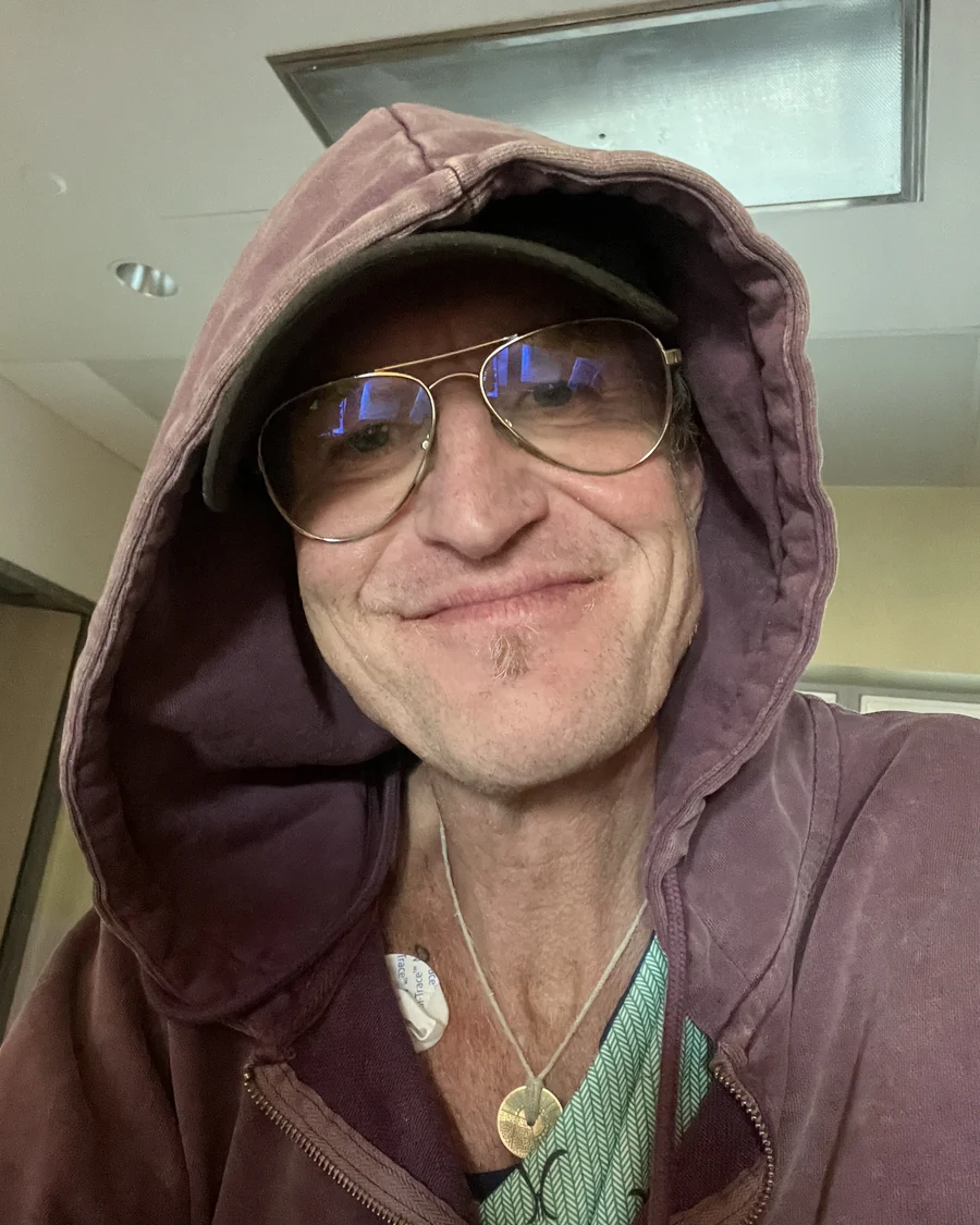 Jasen Rockliffe in a hospital ward in Oakville, Ontario, in a hood and glasses, smiling